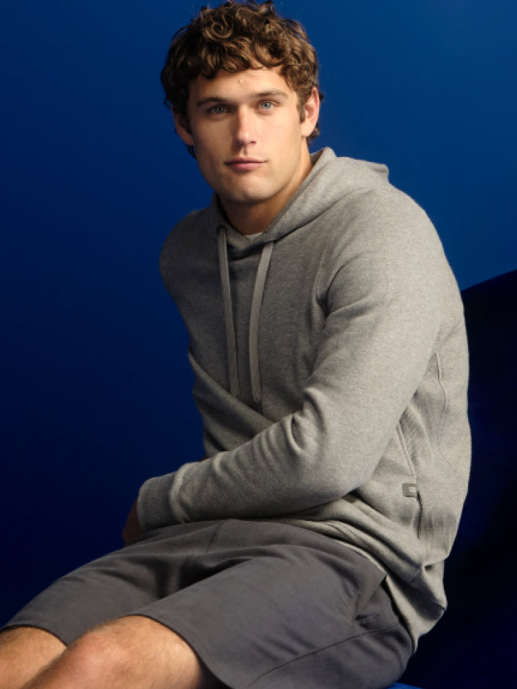 image of a man wearing a grey ACE hoodie and grey ACE sweatshorts