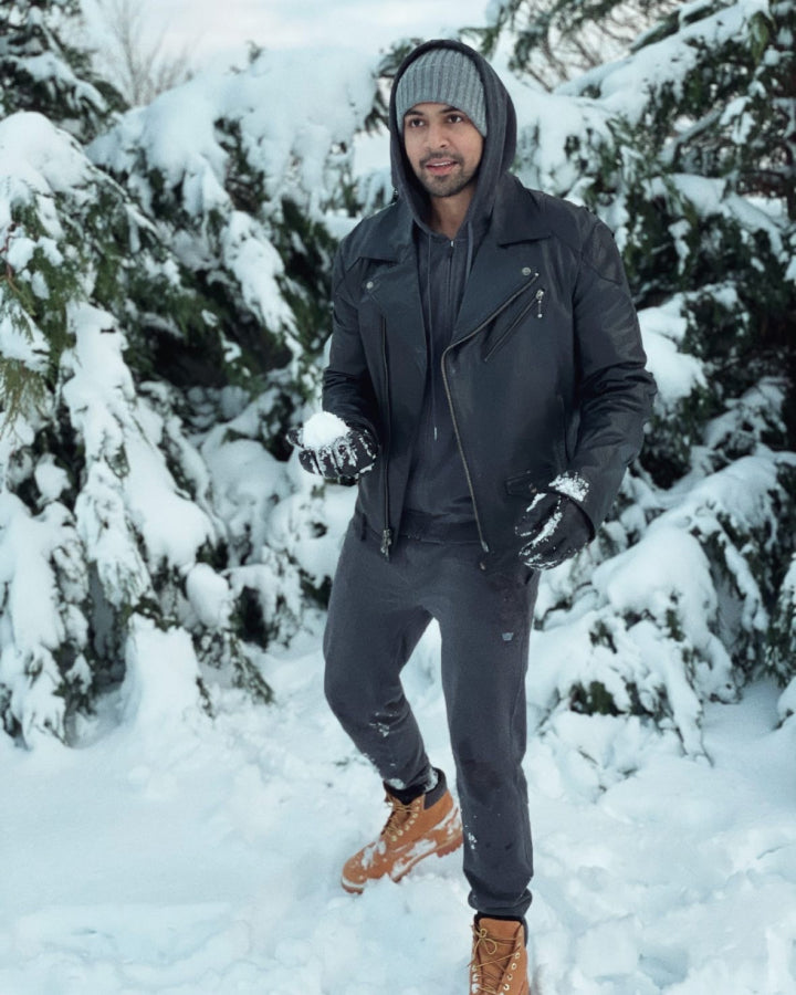 Man stands in snow wearing Mack Weldon full zip hoodie and Mack Weldon sweatpants