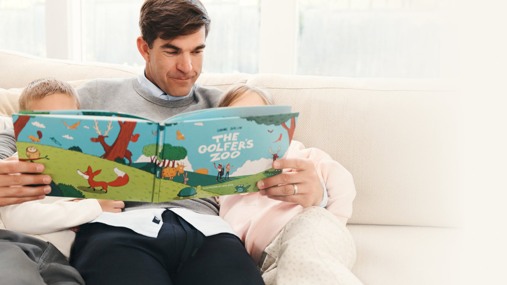 Man with his children reading the golfer's zoo book