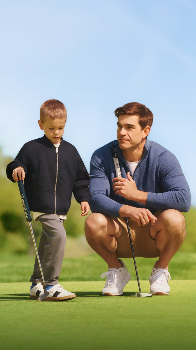 Man with his son playing golf and wearing Tech Merino Quarter-Zip Sweater