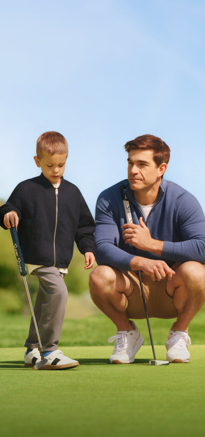 Man with his son playing golf and wearing Tech Merino Quarter-Zip Sweater