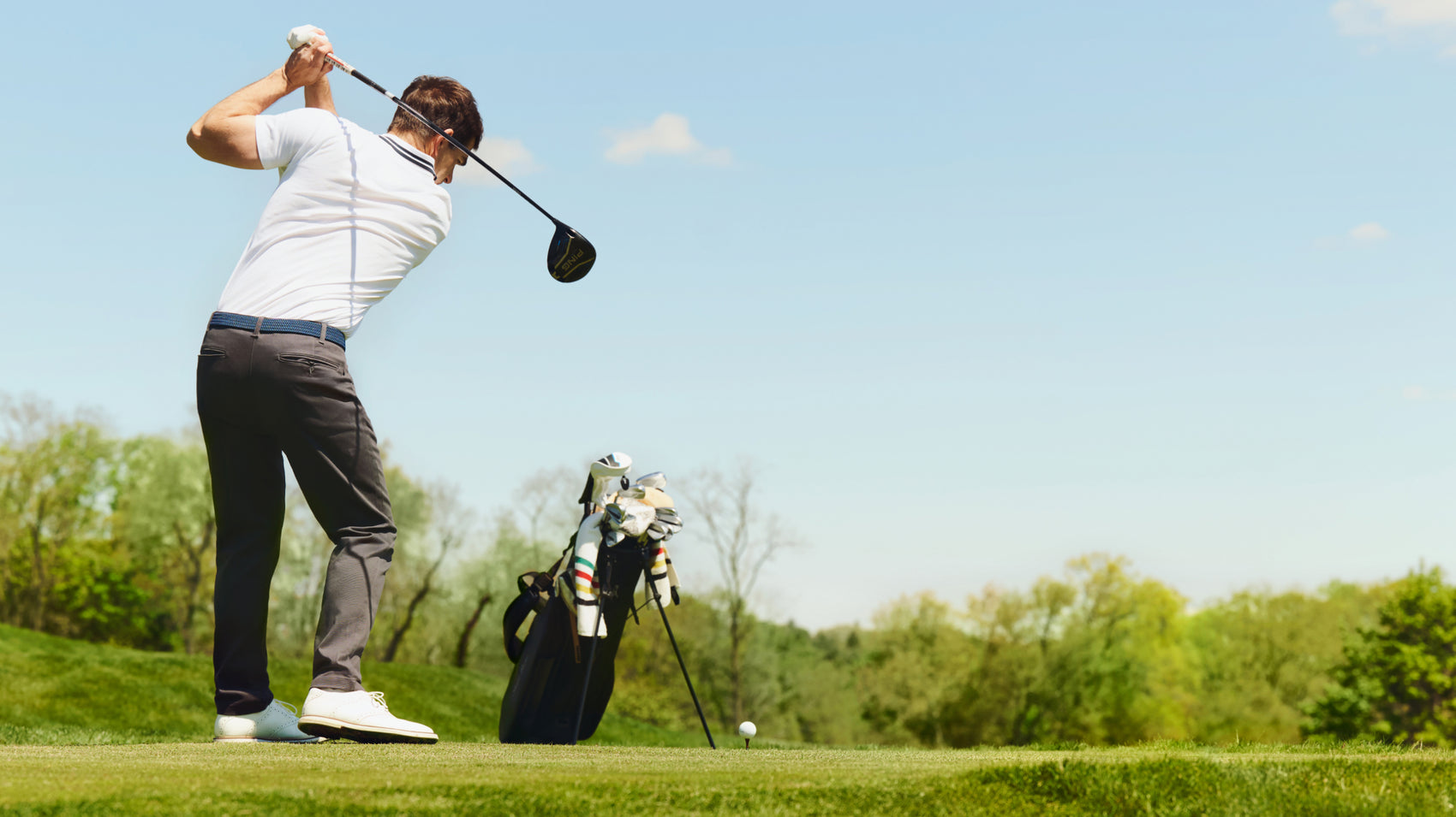 Man playing golf wearing Silver pique polo
