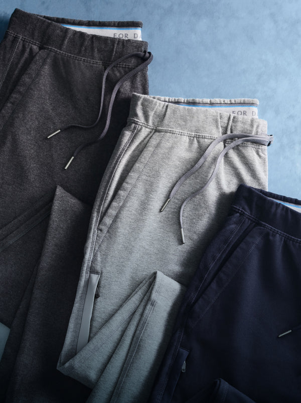 Laydown image of 3 Ace Sweatpants on a blue background 