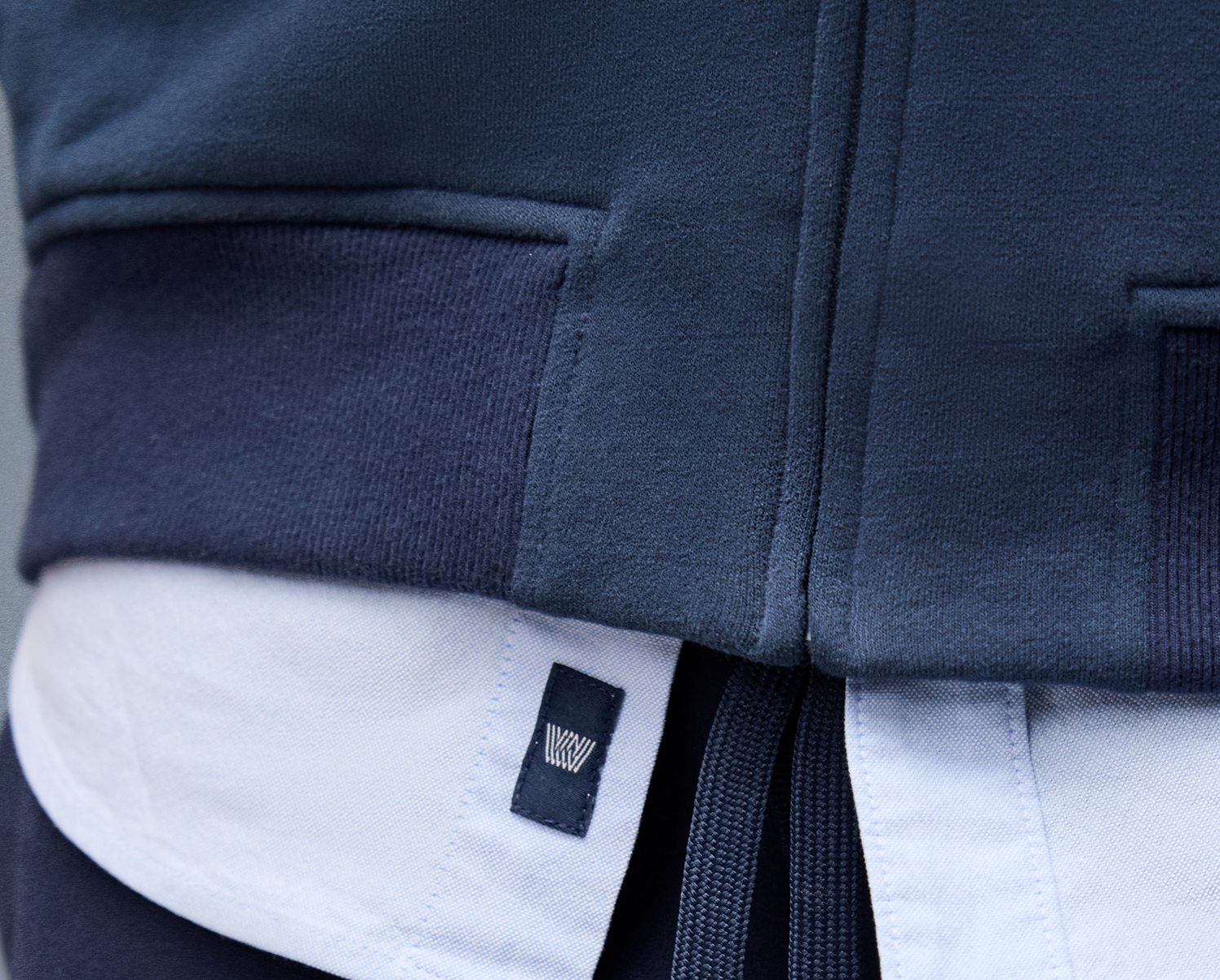 Navy blue jacket with a brand logo on a gray background