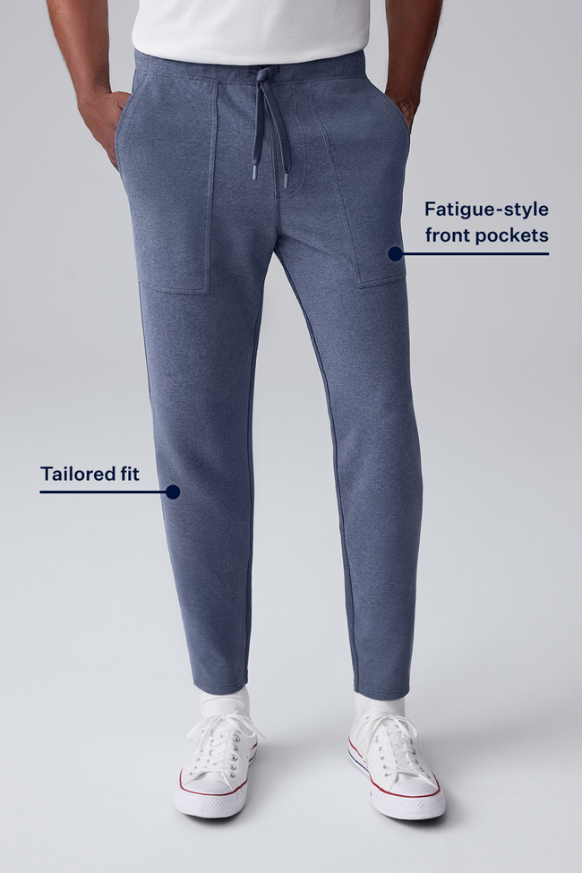 Blue jogger pants with fatigue-style front pockets and tailored fit on a gray background