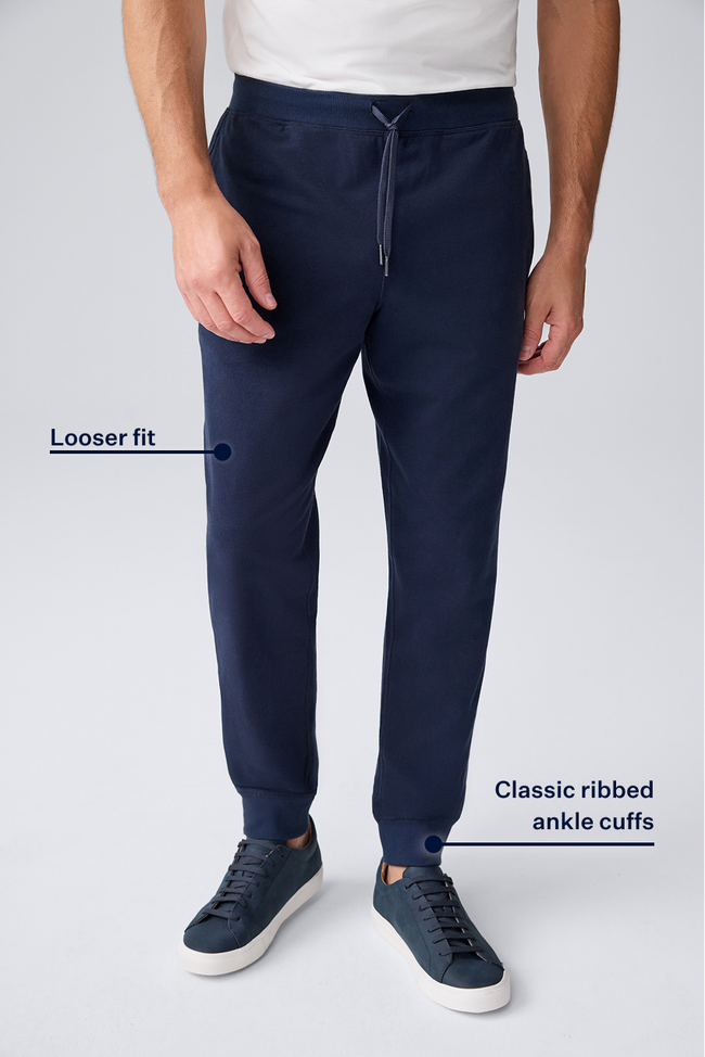 Navy blue pants with ribbed ankle cuffs on a light gray background