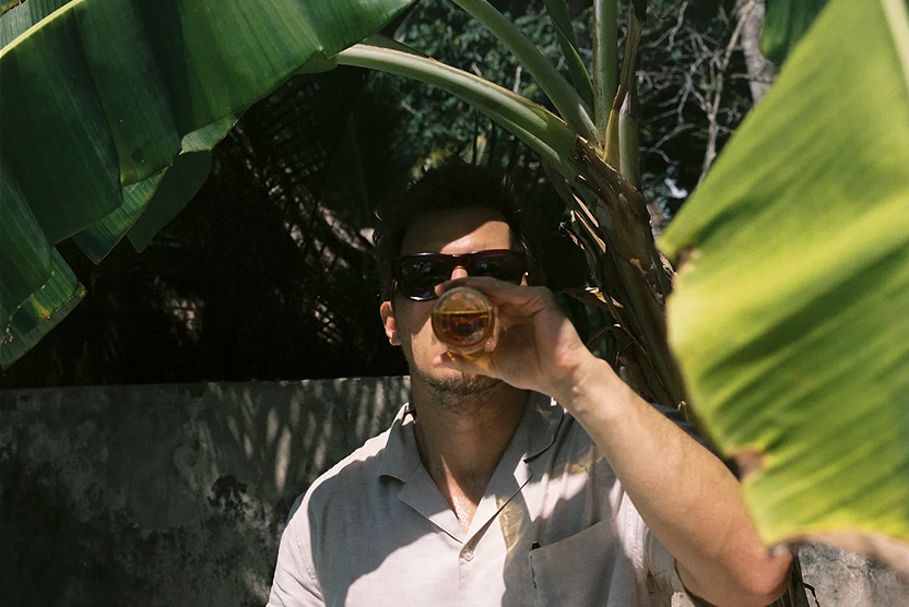 man sipping a drink in the jungle
