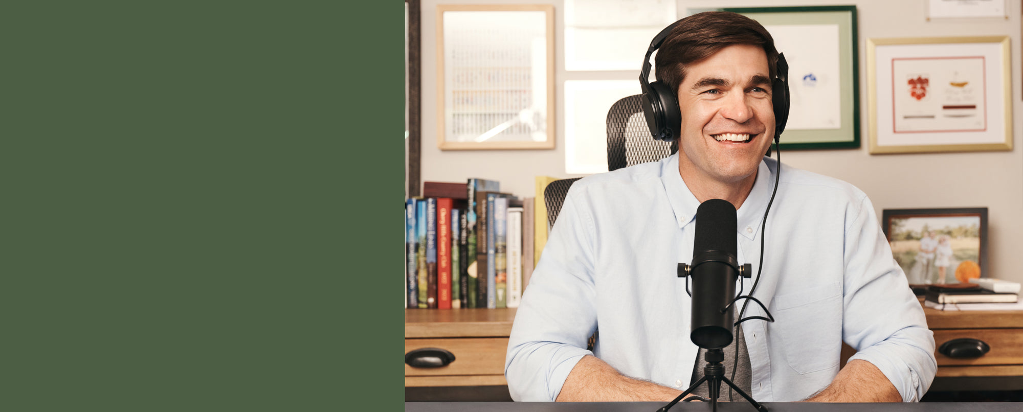 Shane Bacon wearing headphones and recording with a microphone, wearing Dean Oxford.