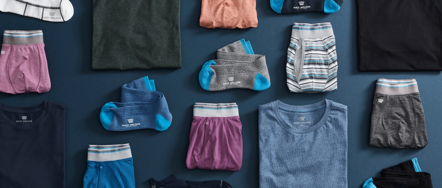 birds-eye view of Mack Weldon clothing laid out on a navy blue ground