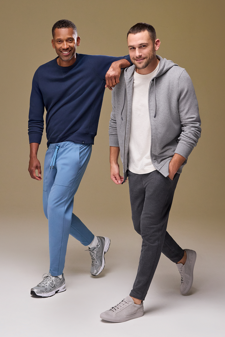 Two men posing together against a plain background