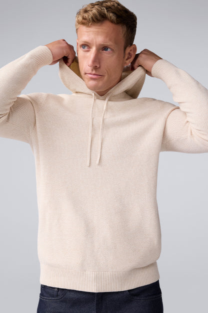 Front facing image of a man in a cream colored, long sleeve hoodie.