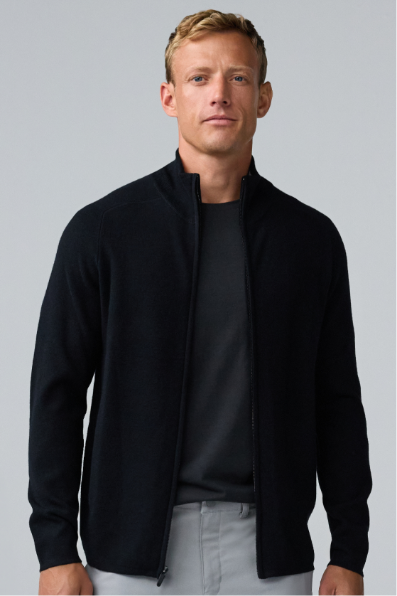 Man wearing a black full-zip sweater over a dark gray shirt.