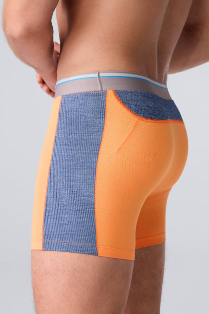 Profile image of a man in 8" Airknitx boxer briefs that are grey and neon orange.