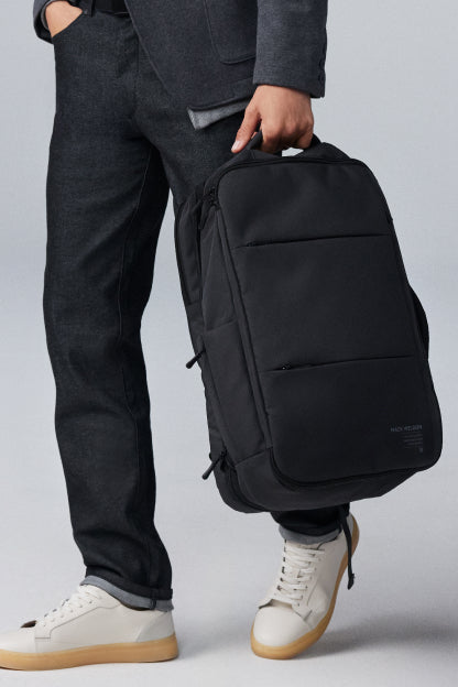 Image of a mean wearing SILVER Denim carrying a Mack Weldon backpack