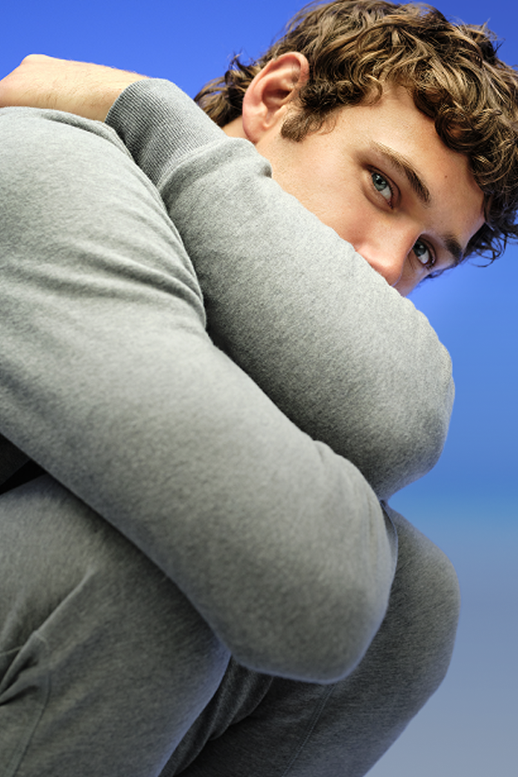 blue backdrop with a man in grew sweatpants